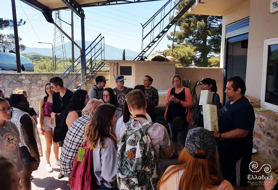 a group of young tourists waiting front the Elladiko olive oil plant outside at entrance